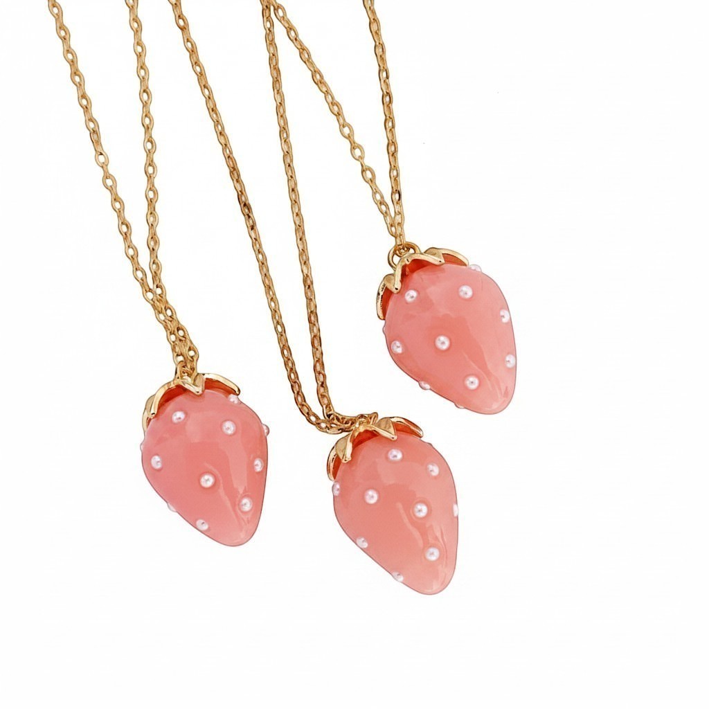 ZOA HANDMADE pink strawberry pendant necklace with pearl seeds and gold stem detail on a gold chain.