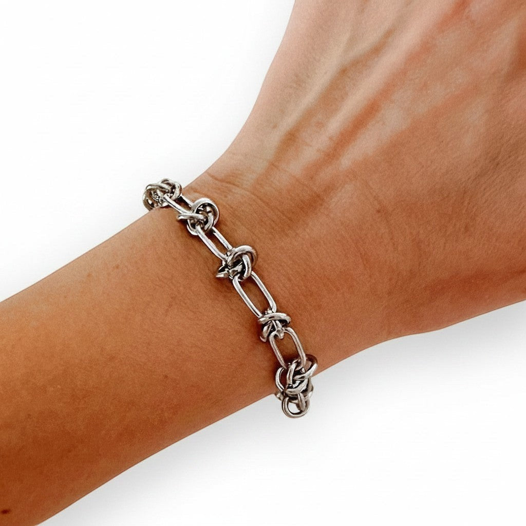 ZOA HANDMADE silver knot link bracelet on a wrist, adjustable length