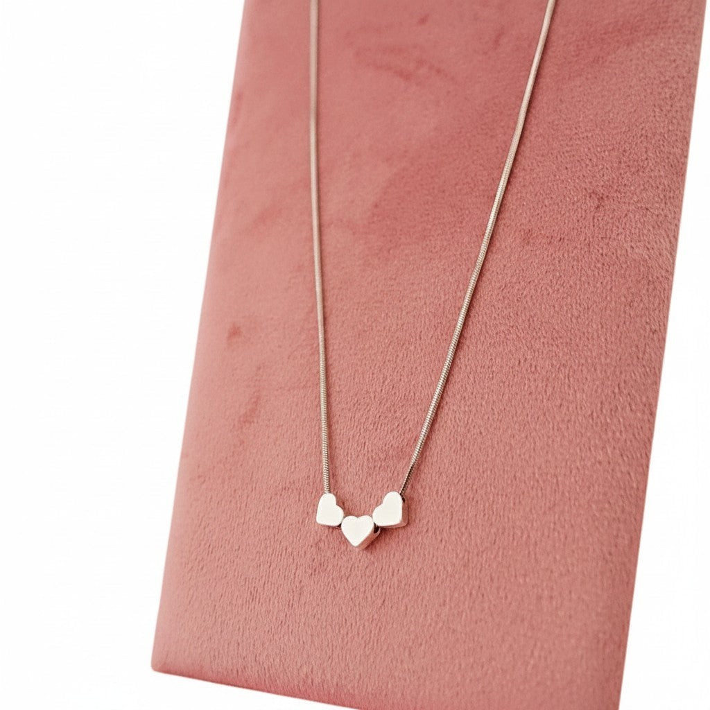 ZOA HANDMADE silver-tone stainless steel necklace with three small heart charms on a snake chain.